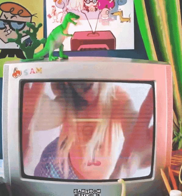 a cartoon network tv with a toy dinosaur on top