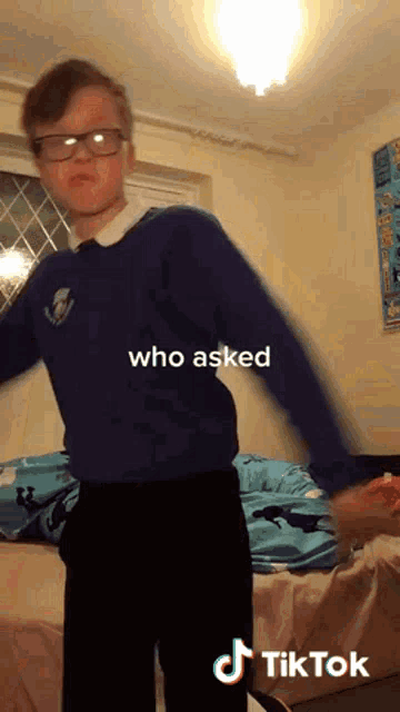 a boy wearing glasses and a blue sweater with the words who asked on the top