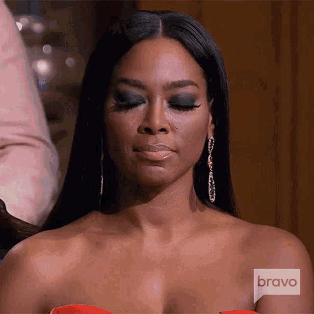 a woman wearing a red dress and earrings is on bravo television