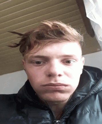 a young man wearing a black jacket looks at the camera with a serious look on his face