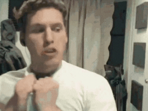 a man in a white shirt is adjusting his tie in a room .