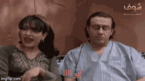 a man and a woman are sitting next to each other and the woman is screaming