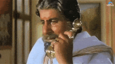 a man with a beard is talking on a phone with venus written on the bottom