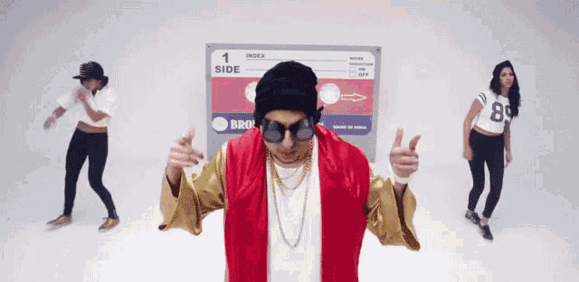 a man in a red jacket is dancing in front of a sign that says index side
