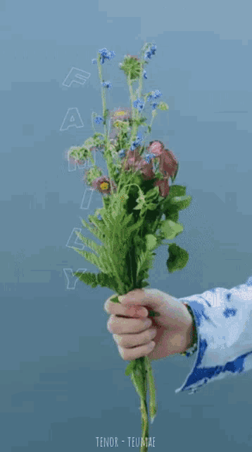 a man with pink hair is holding a bouquet of red roses in front of his face ..