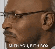 a man wearing glasses and a mustache is talking to someone .