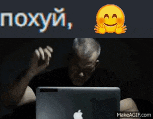 a man sitting in front of an apple laptop with a smiley face on it