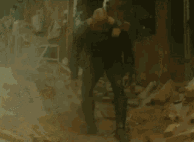 a bald man in a black suit is standing in a ruined building .