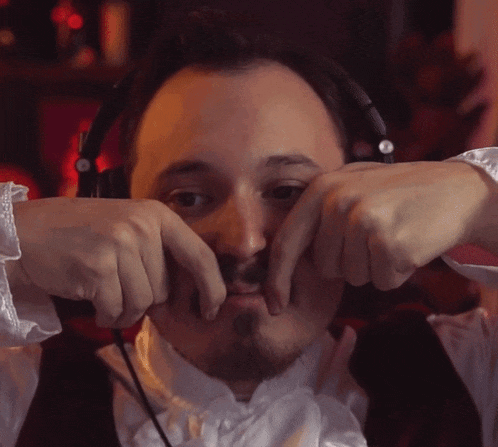 a man is wearing headphones and making a face