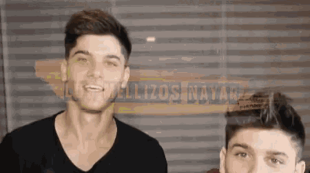 two men are standing next to each other in front of a sign that says ' felizos david '