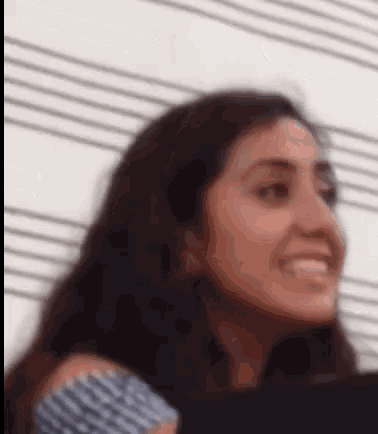 a close up of a woman 's face with a striped shirt on .
