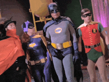a group of people dressed as batman and robin are standing next to each other