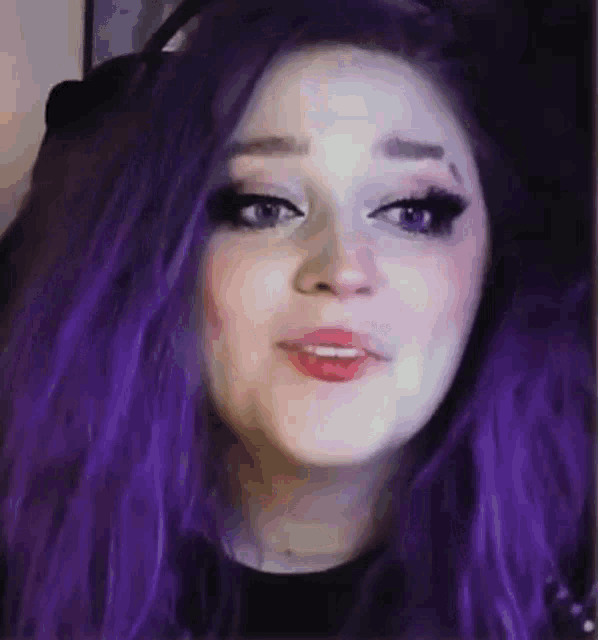 a girl with purple hair is making a funny face .