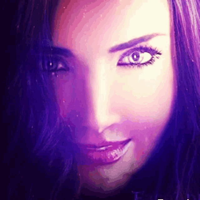 a close up of a woman 's face with purple hair and green eyes