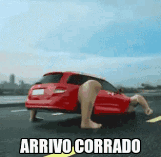 a red car with a person 's legs sticking out of it and the words arrivo corrado above it