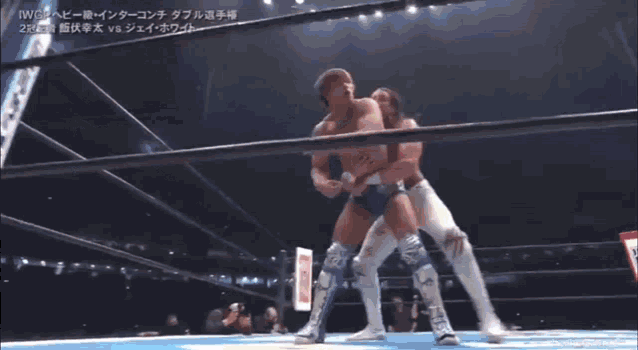 two men are wrestling in a ring and one of them is doing a flip on the other .