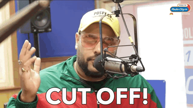 a man in front of a microphone with the words cut off written below him