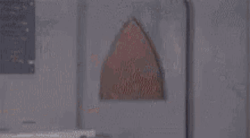a person in a red costume is standing in a room with a blurred background .