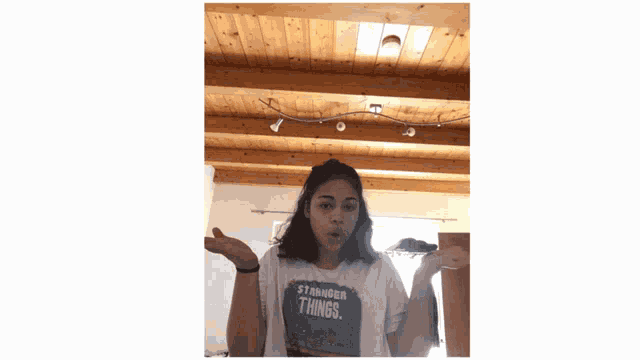 a girl is wearing a t-shirt that says " stranger things "