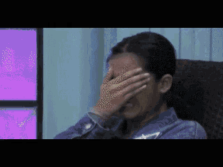 a woman is covering her face with her hand