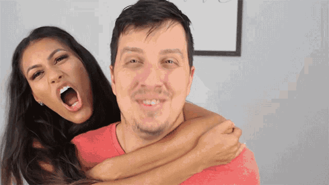 a woman is holding a man in her arms with her mouth wide open