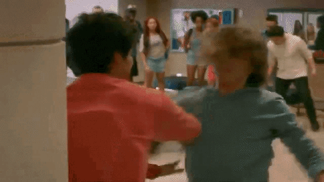 a group of people are fighting in a hallway .