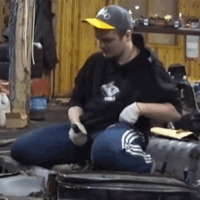 a man wearing a hat with the letter o on it is sitting in a chair