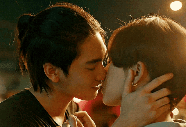a man and a woman are kissing and the woman has earrings in her ear