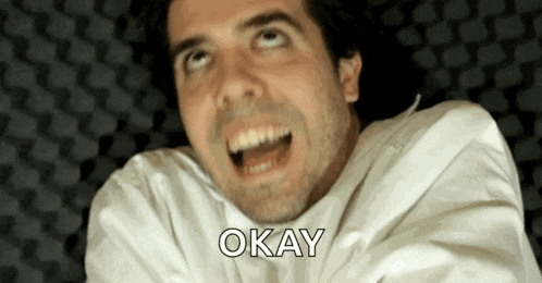a man in a white shirt is saying okay