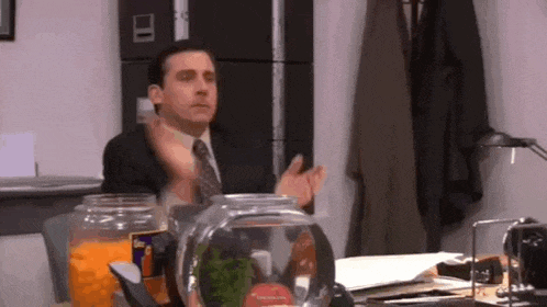 a man in a suit and tie is sitting at a desk .
