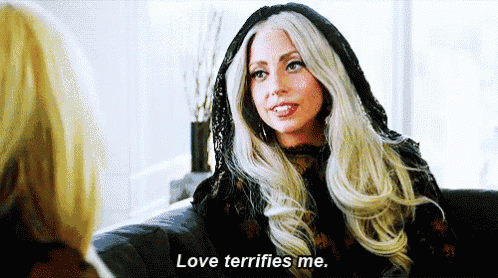 lady gaga is sitting on a couch talking to another woman and saying `` love terrifies me . ''