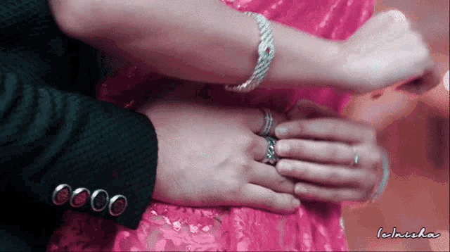 a man putting a ring on a woman 's finger with the name ichisha written on the bottom