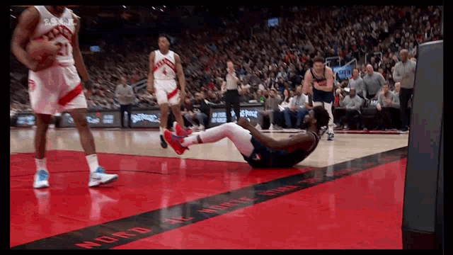 a basketball player is laying on the floor during a game with the word north on the floor