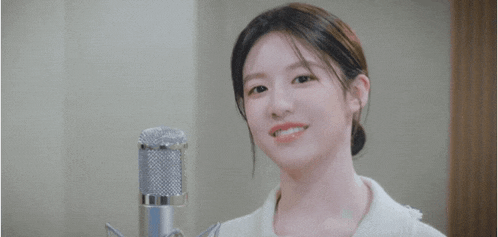 a young woman is smiling in front of a microphone