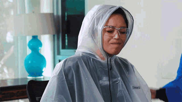 a woman wearing a clear coleman poncho and goggles