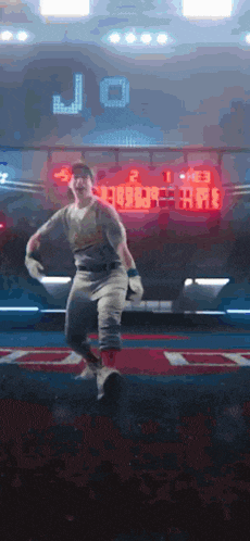 a man in a baseball uniform is jumping in the air in front of a scoreboard with the letter j on it