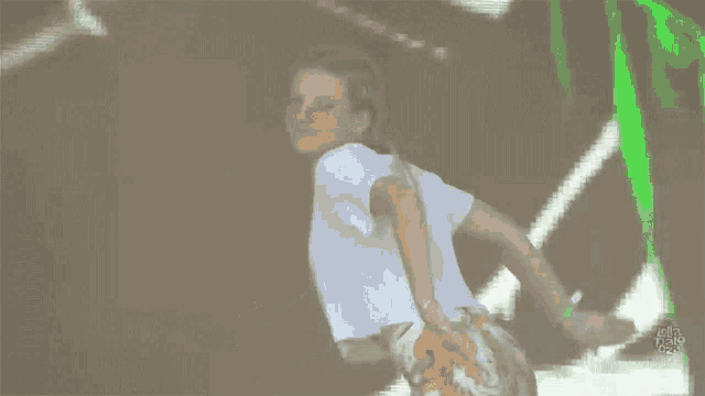 a woman in a white shirt and floral skirt is dancing