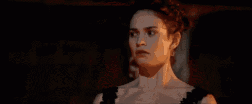 a woman and a zombie are standing next to each other in the dark .