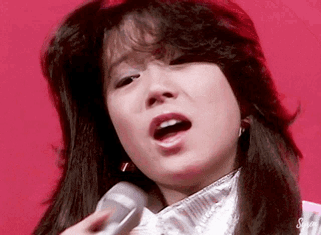 a close up of a woman singing into a microphone