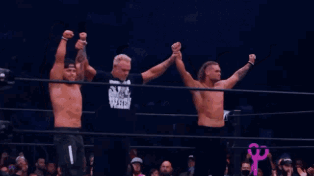 three men in a wrestling ring with one wearing a shirt that says star wars