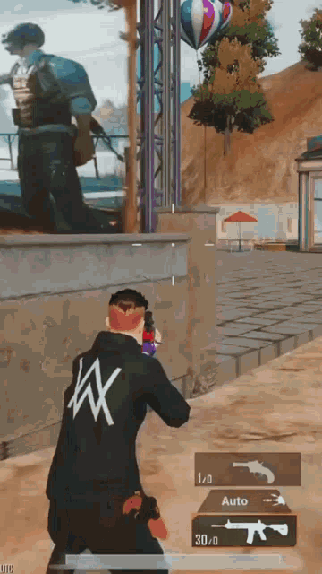 a man in a black jacket with the letter x on it is playing a video game