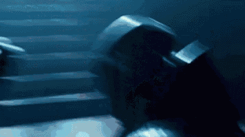 a person is standing on a set of stairs in a dark room holding a dumbbell .