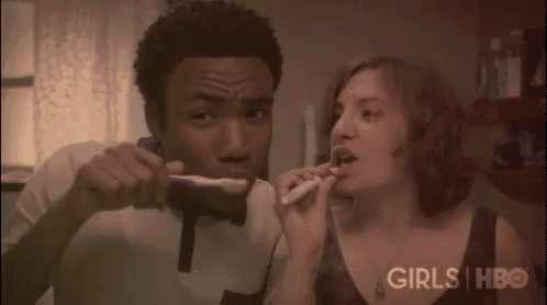 a man and a woman are brushing their teeth together in a girls hbo ad