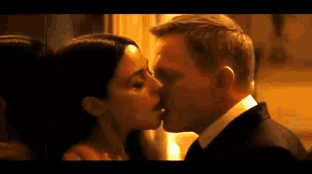 a man and a woman are kissing in a room in a movie .