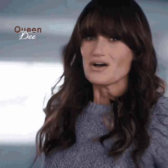 a woman is wearing a purple sweater with queen bee written on the bottom