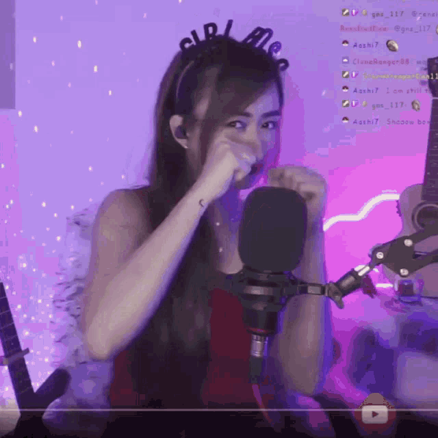 a woman wearing a headband that says girl on it stands in front of a microphone