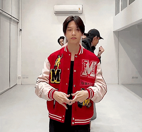 a man wearing a red jacket with the letter m on the front