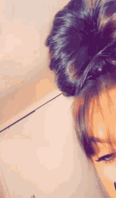 a close up of a woman 's hair in a messy bun