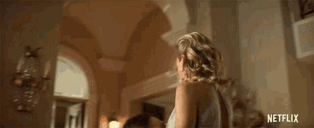 a woman in a blue dress is drinking a glass of wine .