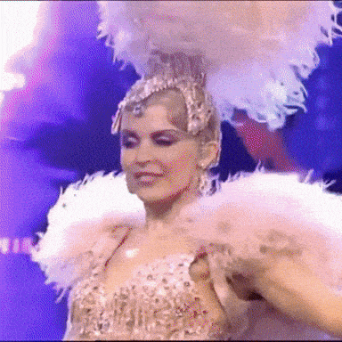 a woman is wearing a feathered headpiece and a feathered collar